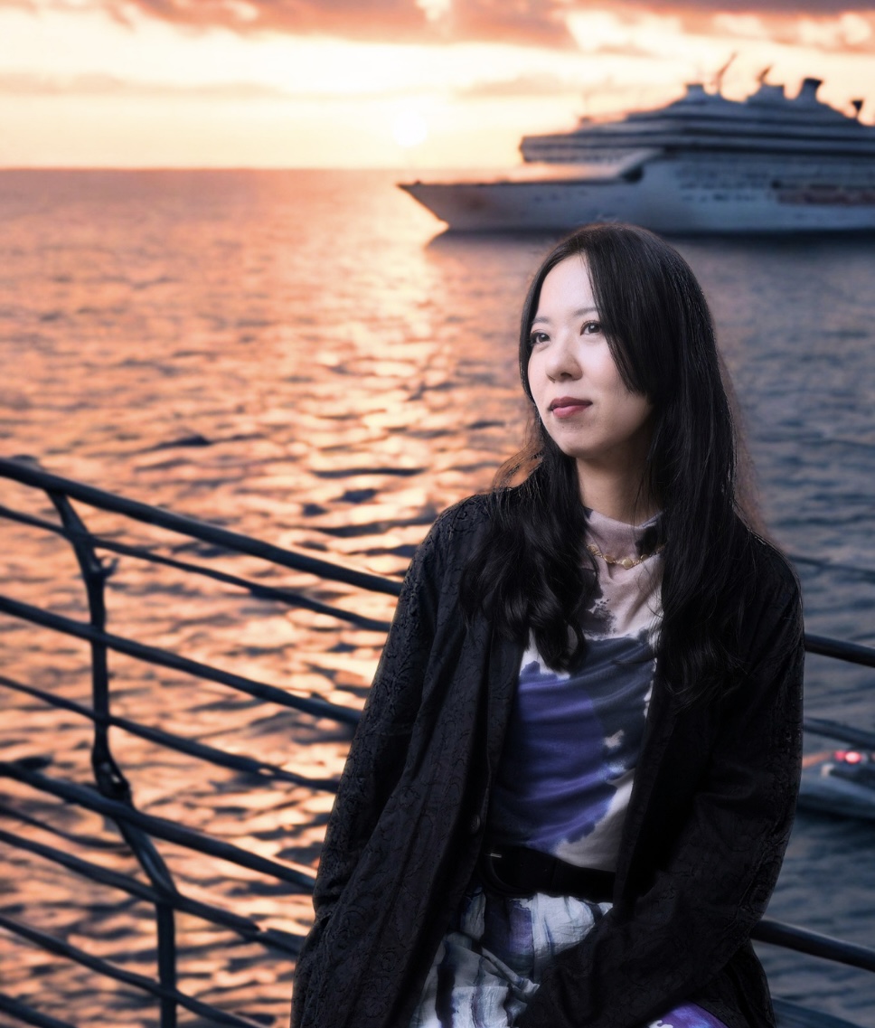 夕暮れの海を背景にした山地真美のポートレート