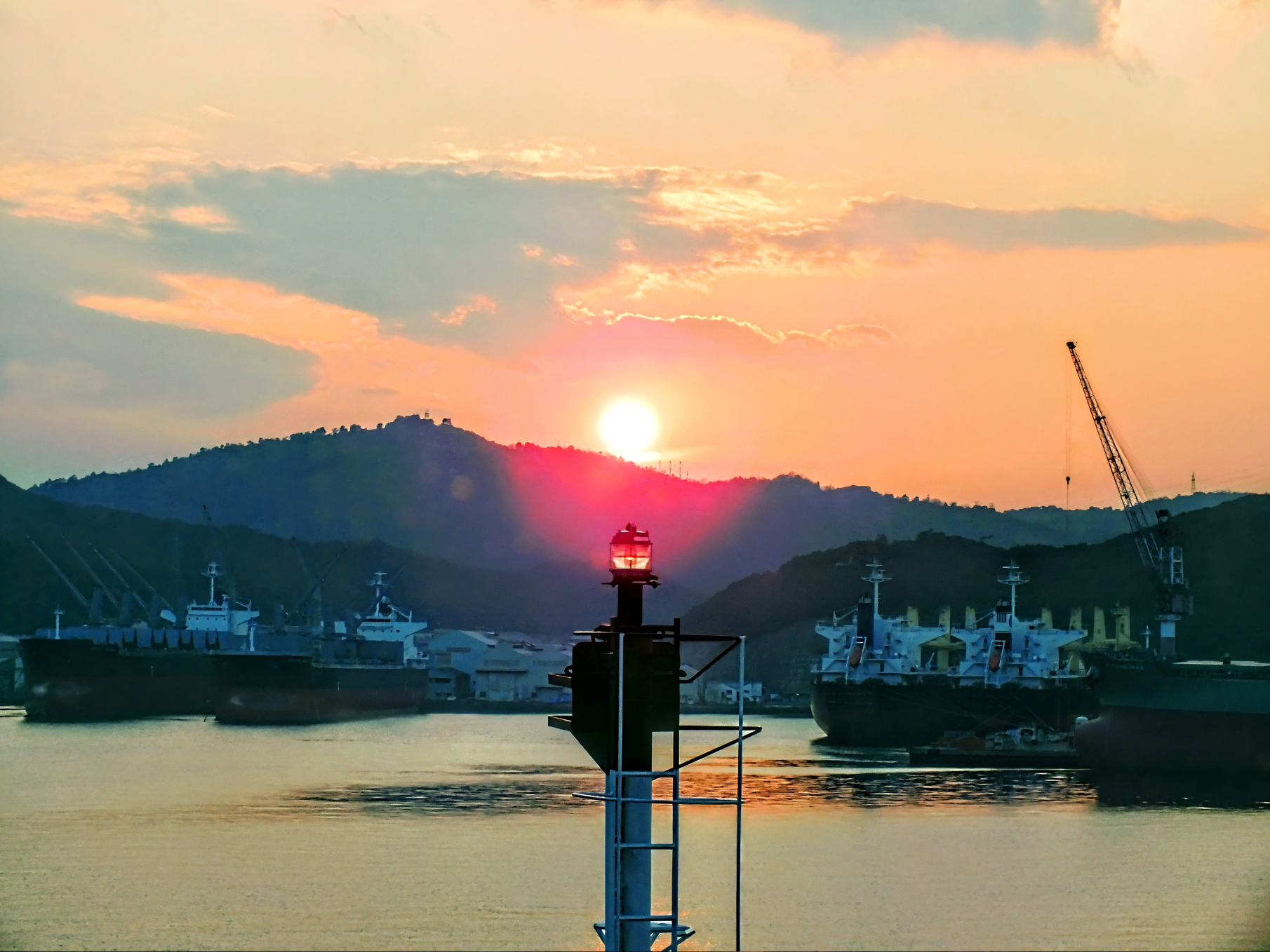 夕日が沈む宇野港と、港に停泊する船の風景